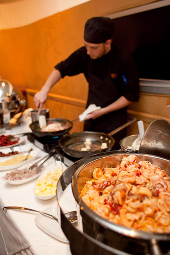 Shrimp and Grits being cooked with all of the components involved Shrimp and Grits being cooked with all of the components involved