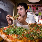 Seth chowing down on a large pizza